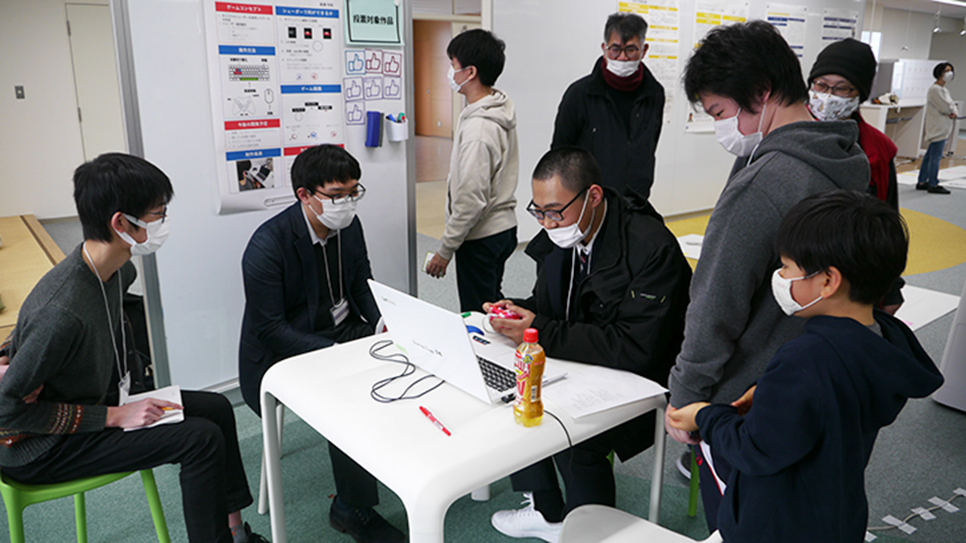 制作したゲームで先生と生徒が一緒に楽しむ写真