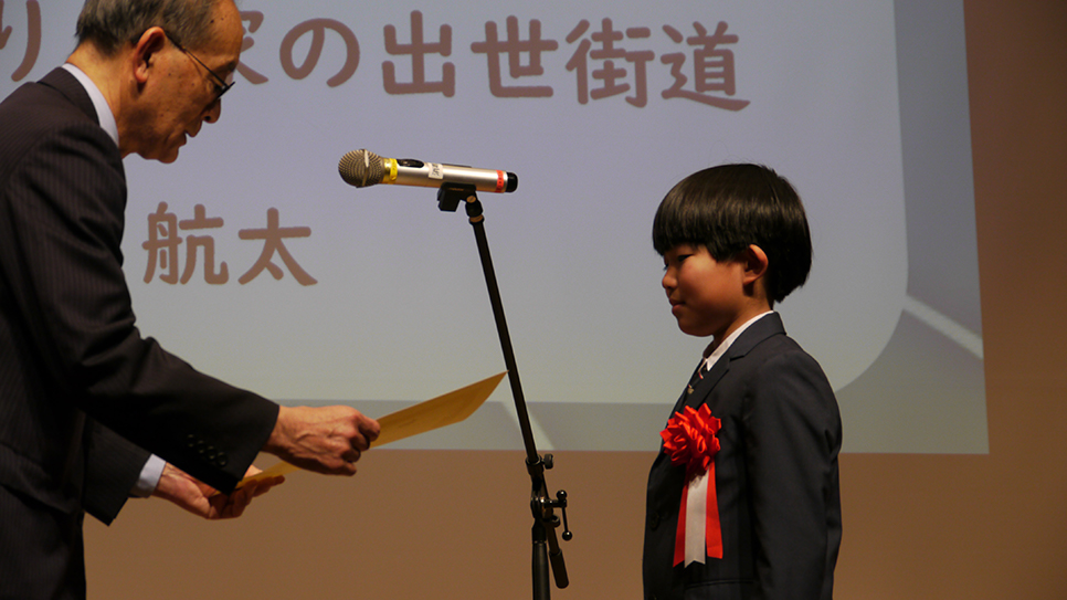 緊張した面持ちで嬉しそうに賞状を受け取る生徒の様子